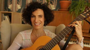 Foto von Olive Christou mit Gitarre